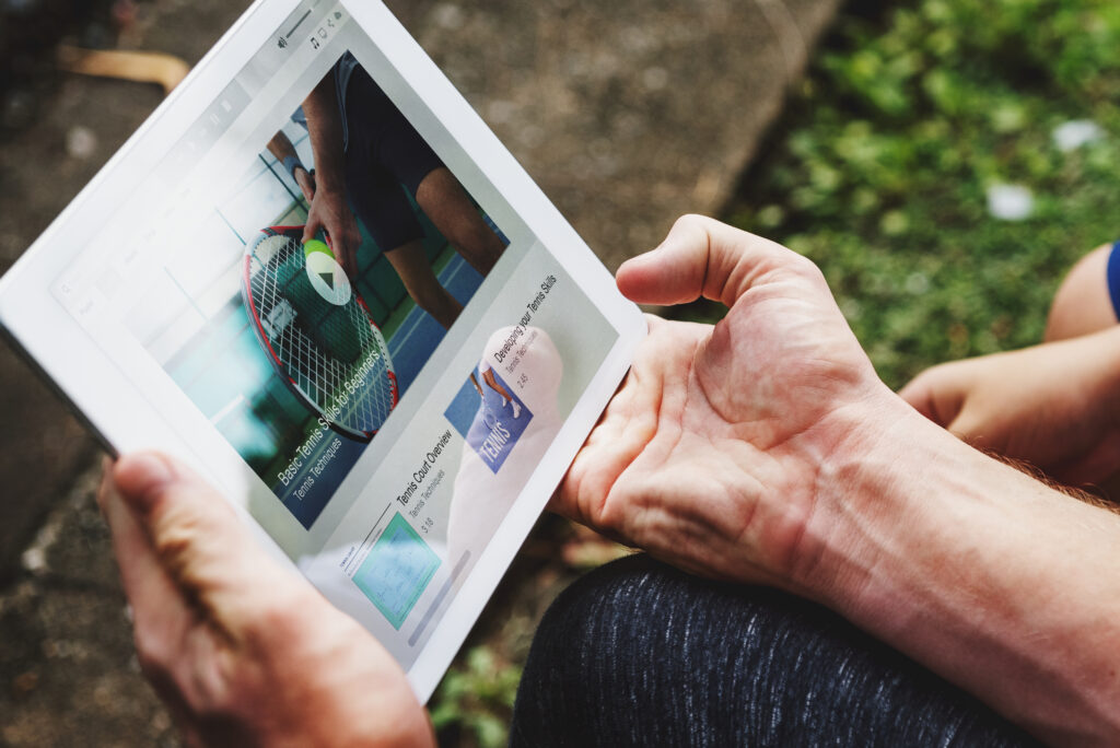 Person holding a tablet on which a video is playing