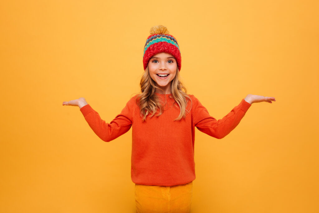 Criança com uma roupa laranja que remete a marca da Alphabeto